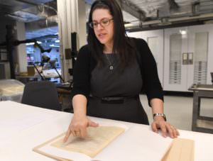 Curator Kyra Schuster goes over a manuscript of Primo Levi's famous holocaust memoir, "Survival in Auschwitz," which was donated to the U.S. Holocaust Memorial Museum in Washington. (Linda Davidson/The Washington Post)
