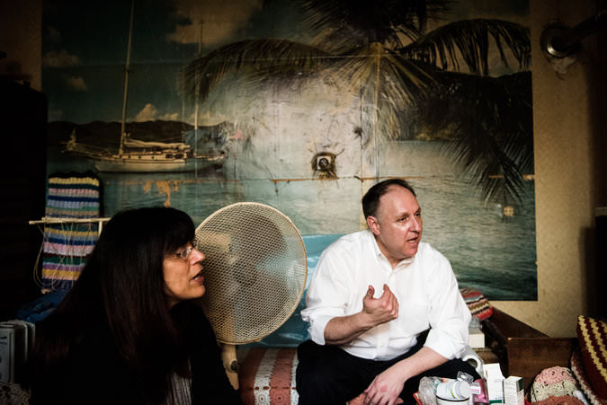 Taly Shaul, the director of the Hungarian Jewish Social Support Foundation, and Greg Schneider, the executive vice president of the Conference on Jewish Material Claims Against Germany, visiting Vera Varga, a Holocaust survivor, in her home in Budapest. Akos Stiller for The New York Times