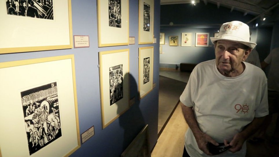 In this Thursday, Sept. 8, 2016 photo, Murray Greenfield, 90, walks around an exhibition about interned Jews at the Center of Visual Arts and Research in capital Nicosia, Cyprus. (AP Photo/Petros Karadjias)